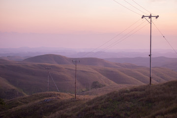 Line of power pole during the misty morning on Wairinding Hill on East Sumba, Indonesia