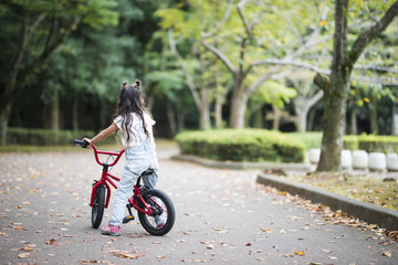 Fototapeta na wymiar Happy little girl riding a bicycle