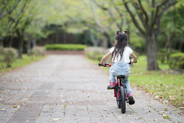 Happy little girl riding a bicycle