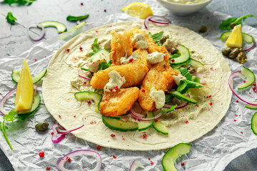 Fresh Fish Tortilla with cucumber, red onion, Capers, lemon, salad leaves and tartare sauce. Healthy Food