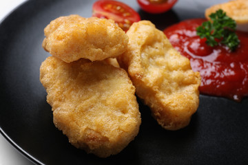 Tasty nuggets and sauce for chicken on plate, closeup