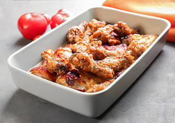 Tasty chicken with sauce in baking dish on table