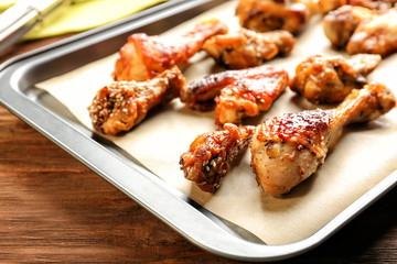 Tasty chicken with sauce on baking tray, closeup