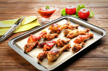 Tasty chicken with sauce on baking tray