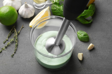 Blending creamy sauce for fish taco in bowl on kitchen table