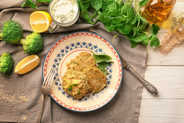 Broccoli pancakes served with grated cheese and basil leaves on patterned plate