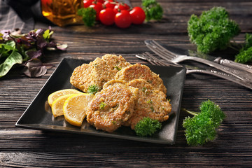 Broccoli pancakes served with lemon on black plate