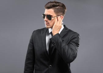 Handsome security guard on grey background