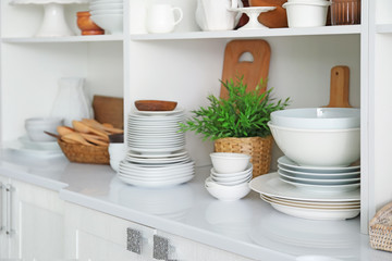 White storage stand with ceramic and wooden dishware in kitchen