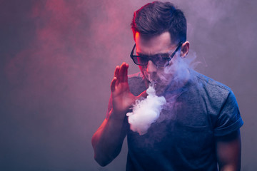 man with beard vaping an electronic cigarette. Vaper hipster smoke vaporizer.