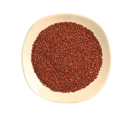Plate with red quinoa grains, isolated on white