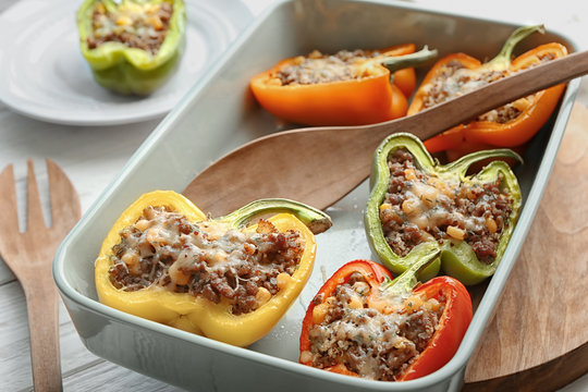 Quinoa stuffed peppers and wooden spoon in baking dish
