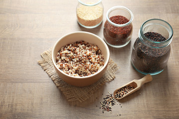 Bowl with boiled quinoa grains on wooden table