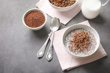 Bowl with boiled quinoa grains and milk on kitchen table