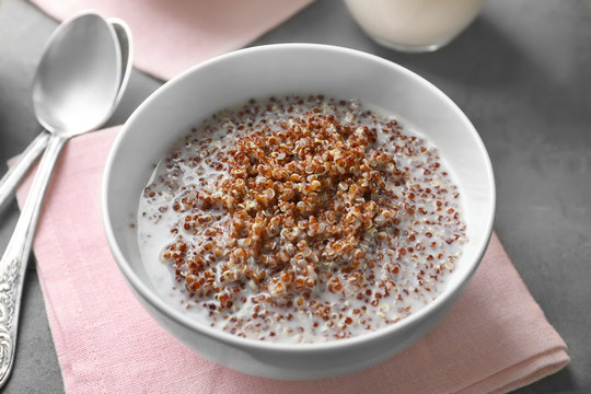 Bowl with boiled quinoa grains and milk on kitchen table