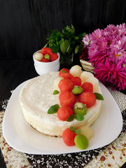 White cake decorated with watermelon, melon and kiwi ball-shaped pieces