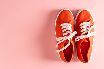 Classic red sneakers on a pale pink background