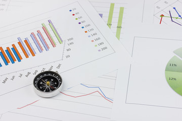 compass with graph chart as a background - business concept