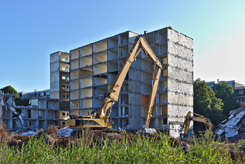 Fototapeta na wymiar Demolished residential building being torn down by two excavators
