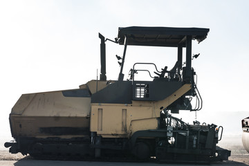 Image of asphalt spreader machine with yellow color,