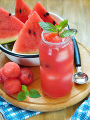 Watermelon segments and a refreshing drink with ice and decorated with mint