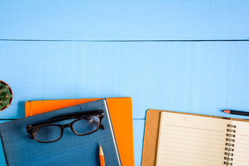 top view book mockup and pencil note on blue wood table