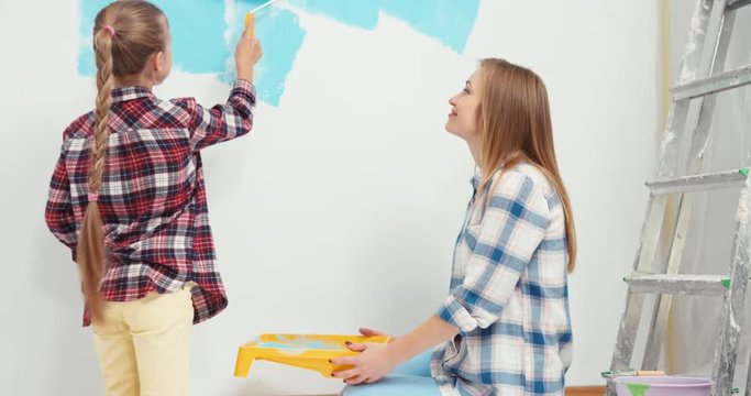Cheerful family painting wall at home