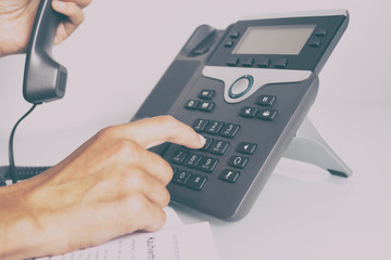 Telefon im Büro mit Hand und Hörer