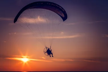 Photo sur Plexiglas Sports aériens Paraglider flying at sunset