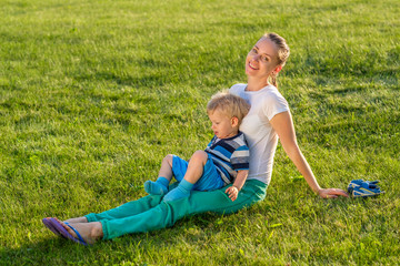Naklejka na ściany i meble Happy woman and child having fun outdoor on meadow