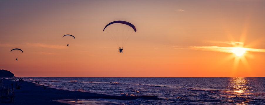Paragliders flying at sunset