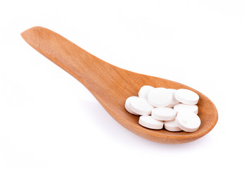 Fototapeta na wymiar white pills in spoon isolated on white background