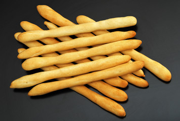 Italian bread, crispy grissini on a dark background. Close-up.