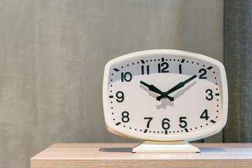 Modern white clock on the wooden table luxurious contemporary decoration