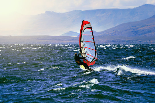 Sportman windsurfer on the lake surface.