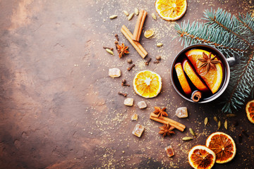 Christmas mulled wine or gluhwein with spices and orange slices on rustic table top view. Traditional drink on winter holiday. Copy space for recipe.