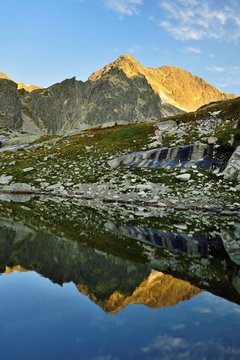 Sunrise in High Tatras in Slovakia. Monumental Ladovy peak. Summer scenic landscape mountain view. Alpine trail. Small cold valley.