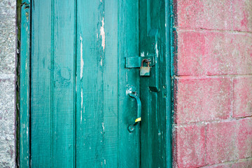 locked green door in a red cinder block facade