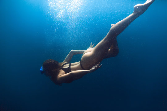 Slim woman swimming in sea. Underwater view