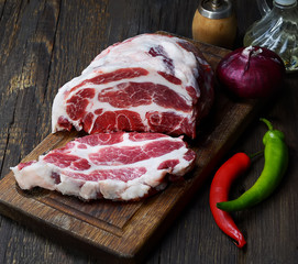 piece of raw pork on a wooden background