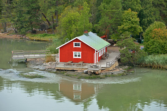  Traditional wooden red scandinavian house on shoreline of Turku archipelago island