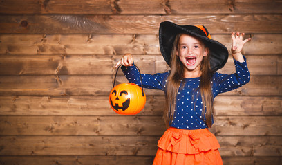 funny child girl in witch costume in halloween