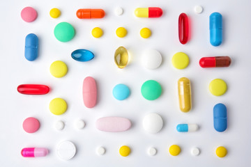 Different colorful pills on white background