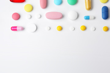 Different colorful pills on white background