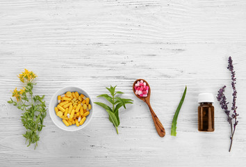 Colorful pills and herbs on wooden background