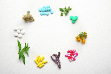 Colorful pills and herbs in shape of circle on white background
