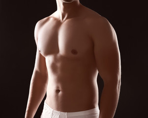 Fototapeta premium Sporty young man on dark background