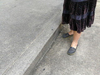 grey shoes on asian female legs standing on the floor., copy space