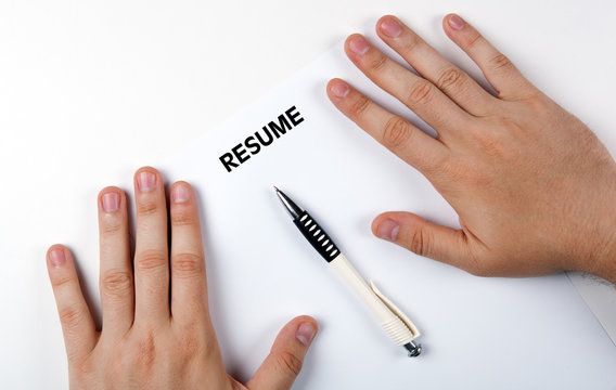 Man's hands on resume form and pen