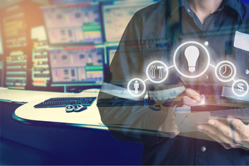 Double exposure of Engineer or Technician man with business industrial tool icons while using tablet with monitor of computers room  for oil and gas industrial business concept